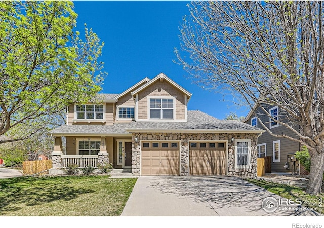 1602 Prairie Song Pl, Longmont, CO 80504 - craftsman-style home featuring concrete driveway, a porch, stone siding, and a front lawn