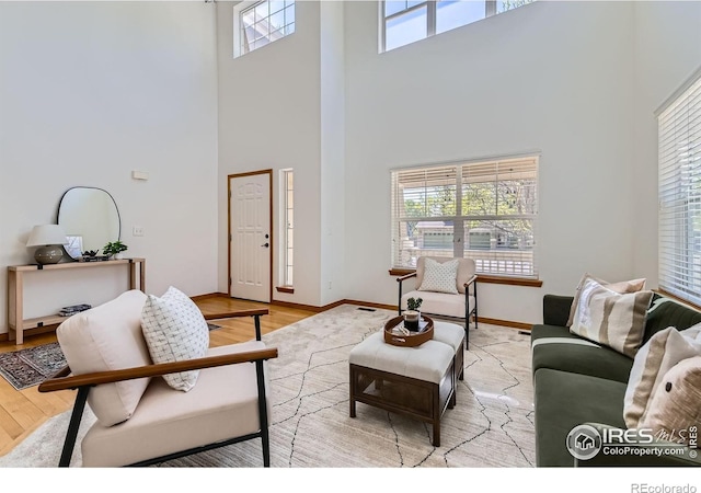 1602 Prairie Song Pl, Longmont, CO 80504 - living area with baseboards, a towering ceiling, and wood finished floors