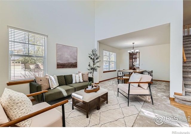 1602 Prairie Song Pl, Longmont, CO 80504 - living room featuring stairway, baseboards, a towering ceiling, and a notable chandelier