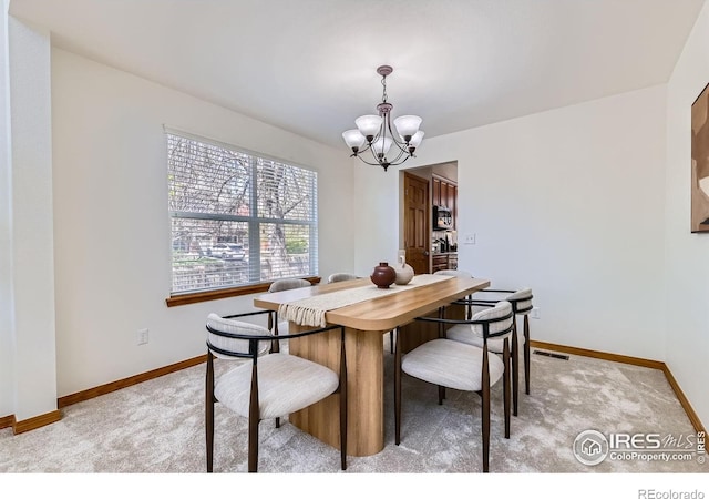 1602 Prairie Song Pl, Longmont, CO 80504 - dining space with baseboards, a chandelier, light carpet, and visible vents