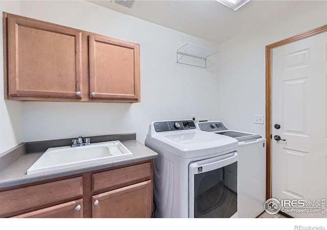 1602 Prairie Song Pl, Longmont, CO 80504 - laundry room featuring visible vents, a sink, cabinet space, and washing machine and clothes dryer