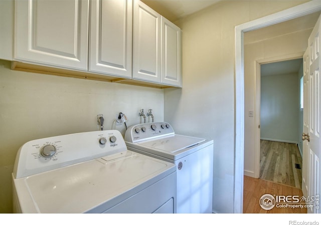 810 34th St, Boulder, CO 80303 - washroom with cabinet space, light wood finished floors, and washer and dryer
