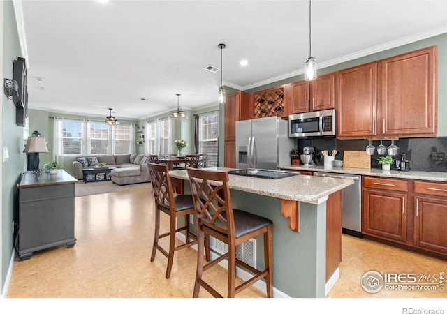 12820 King St, Broomfield, CO 80020 - kitchen with appliances with stainless steel finishes, backsplash, a kitchen breakfast bar, a center island, and ornamental molding