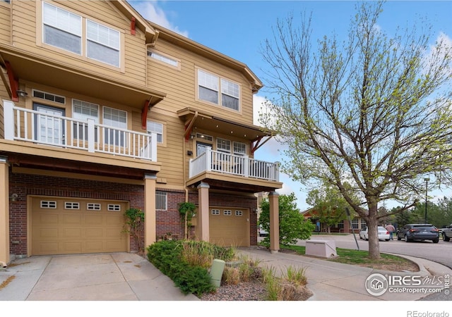 12820 King St, Broomfield, CO 80020 - view of property with an attached garage, brick siding, driveway, and a balcony