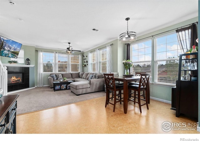 12820 King St, Broomfield, CO 80020 - dining area featuring plenty of natural light, ornamental molding, baseboards, light floors, and a glass covered fireplace