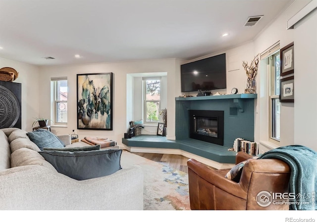 4475 Laguna Pl Unit 206, Boulder, CO 80303 - living room featuring a glass covered fireplace, healthy amount of natural light, wood finished floors, and recessed lighting