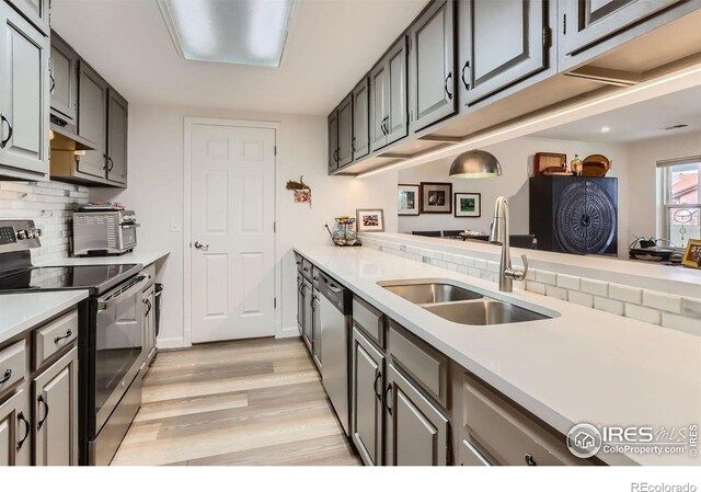 4475 Laguna Pl Unit 206, Boulder, CO 80303 - kitchen with stainless steel appliances, a sink, light wood-style flooring, light countertops, and tasteful backsplash
