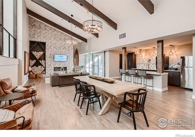 4475 Laguna Pl Unit 206, Boulder, CO 80303 - dining area with light wood-type flooring, a chandelier, beam ceiling, and high vaulted ceiling