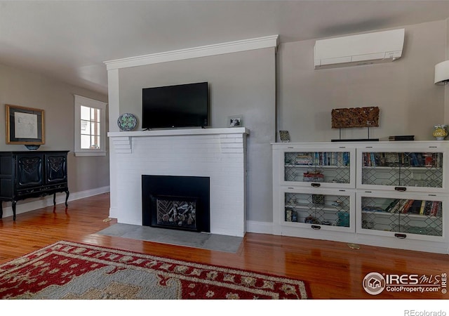 845 14th St, Boulder, CO 80302 - living area featuring baseboards, a wall mounted AC, a brick fireplace, and wood finished floors
