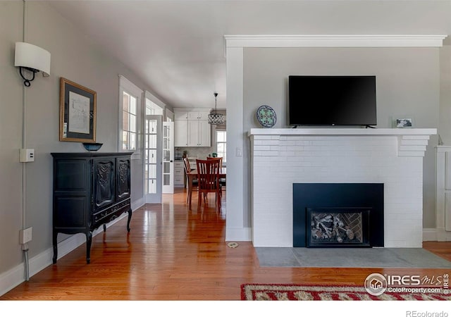 845 14th St, Boulder, CO 80302 - living room featuring a brick fireplace, baseboards, and wood finished floors
