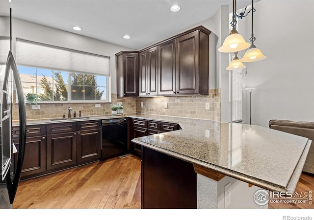4822 Raven Run, Broomfield, CO 80023 - kitchen with tasteful backsplash, dark brown cabinets, a sink, light wood-style floors, and black dishwasher