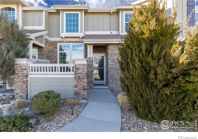 4822 Raven Run, Broomfield, CO 80023 - view of front of property with board and batten siding, an attached garage, and stone siding