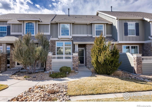 4822 Raven Run, Broomfield, CO 80023 - view of front of home featuring board and batten siding, a shingled roof, and stone siding