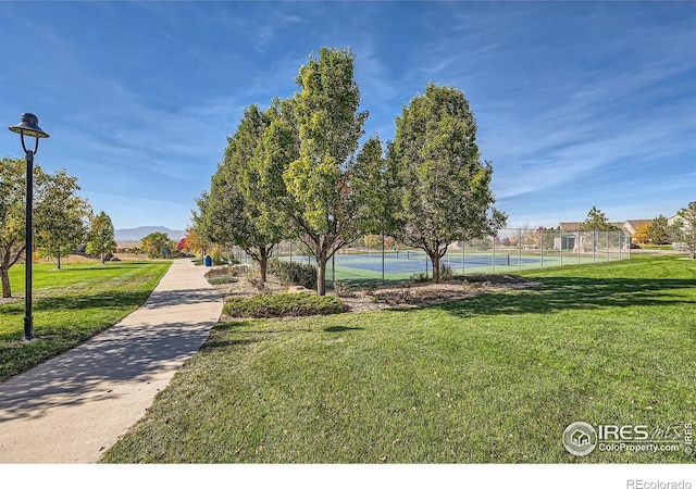 4822 Raven Run, Broomfield, CO 80023 - view of community featuring a lawn, a tennis court, fence, and a mountain view