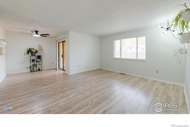 unfurnished living room with baseboards, a textured ceiling, ceiling fan, and light wood-style flooring