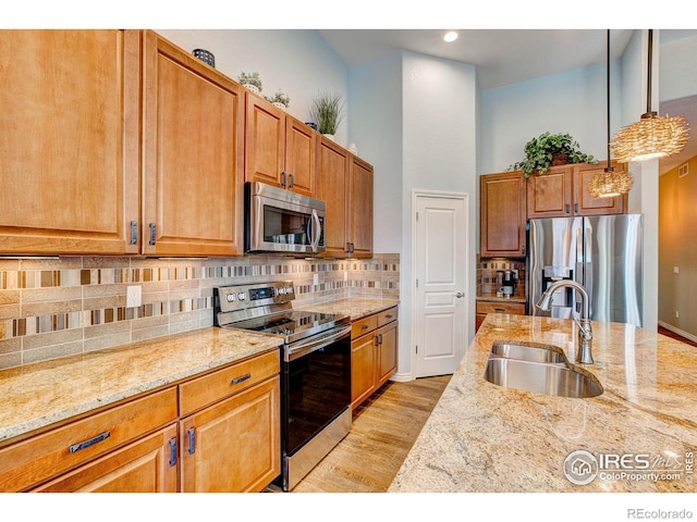 14394 W 88th Dr Unit C, Arvada, CO 80005 - kitchen with light stone countertops, a sink, stainless steel appliances, decorative light fixtures, and tasteful backsplash