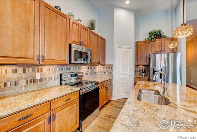 14394 W 88th Dr Unit C, Arvada, CO 80005 - kitchen with stainless steel appliances, light stone counters, backsplash, hanging light fixtures, and recessed lighting