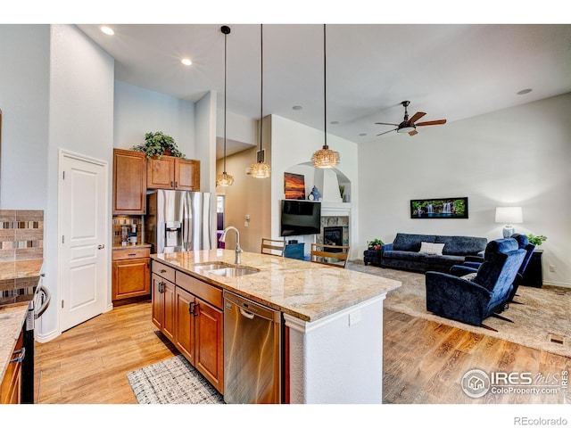14394 W 88th Dr Unit C, Arvada, CO 80005 - kitchen with brown cabinetry, ceiling fan, light wood-type flooring, a sink, and stainless steel appliances
