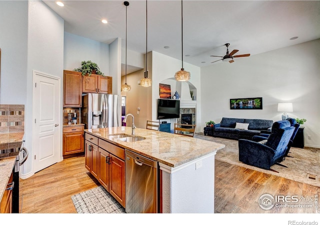 14394 W 88th Dr Unit C, Arvada, CO 80005 - kitchen featuring appliances with stainless steel finishes, light wood-style floors, ceiling fan, hanging light fixtures, and light stone counters