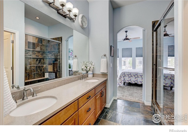 14394 W 88th Dr Unit C, Arvada, CO 80005 - bathroom featuring ceiling fan, connected bathroom, double vanity, a shower stall, and stone finish flooring