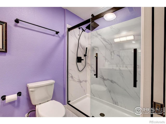 14394 W 88th Dr Unit C, Arvada, CO 80005 - bathroom featuring a marble finish shower, a textured wall, and toilet