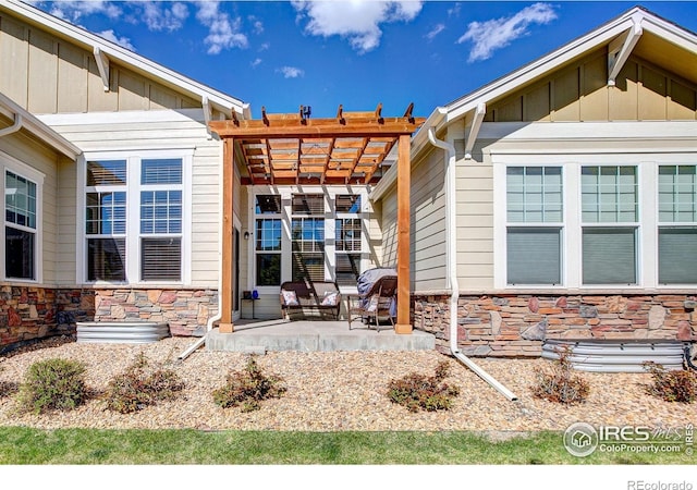 14394 W 88th Dr Unit C, Arvada, CO 80005 - entrance to property with stone siding, a patio, a pergola, and board and batten siding