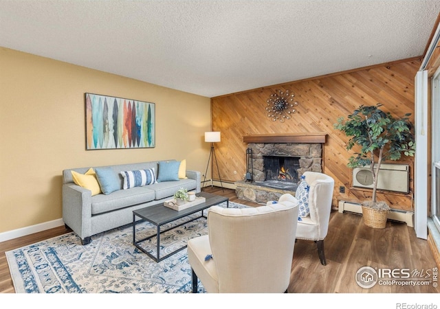 living area featuring a fireplace, a wall mounted AC, baseboards, a baseboard radiator, and wooden walls