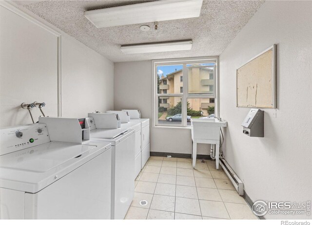 community laundry room with washer and dryer, a textured ceiling, baseboards, light tile patterned floors, and a baseboard radiator