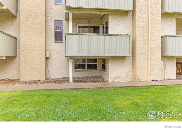 back of property featuring a yard and a balcony