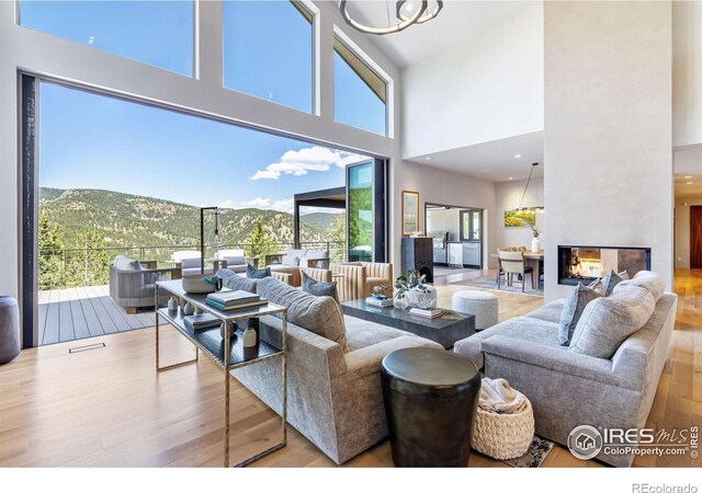 50 Wildwood Ln, Boulder, CO 80304 - living room with wood finished floors, plenty of natural light, a towering ceiling, a multi sided fireplace, and a mountain view