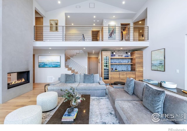 50 Wildwood Ln, Boulder, CO 80304 - living area with high vaulted ceiling, wood finished floors, recessed lighting, a glass covered fireplace, and stairway