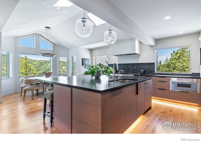 50 Wildwood Ln, Boulder, CO 80304 - kitchen featuring stainless steel oven, modern cabinets, dark countertops, light wood finished floors, and vaulted ceiling