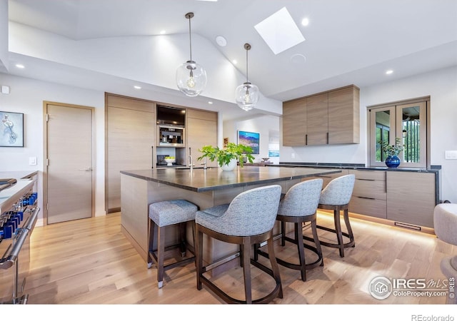 50 Wildwood Ln, Boulder, CO 80304 - kitchen featuring modern cabinets, dark countertops, a skylight, a kitchen breakfast bar, and recessed lighting