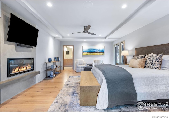 50 Wildwood Ln, Boulder, CO 80304 - bedroom with wood finished floors, a glass covered fireplace, a tray ceiling, ensuite bath, and recessed lighting