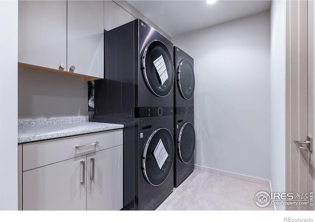 50 Wildwood Ln, Boulder, CO 80304 - washroom featuring stacked washing machine and dryer and cabinet space