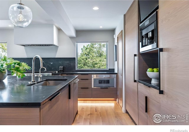 50 Wildwood Ln, Boulder, CO 80304 - kitchen with stainless steel oven, modern cabinets, light wood-type flooring, recessed lighting, and decorative backsplash