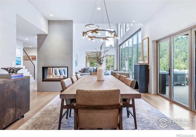 50 Wildwood Ln, Boulder, CO 80304 - dining area featuring light wood-style flooring, recessed lighting, a towering ceiling, stairway, and a multi sided fireplace