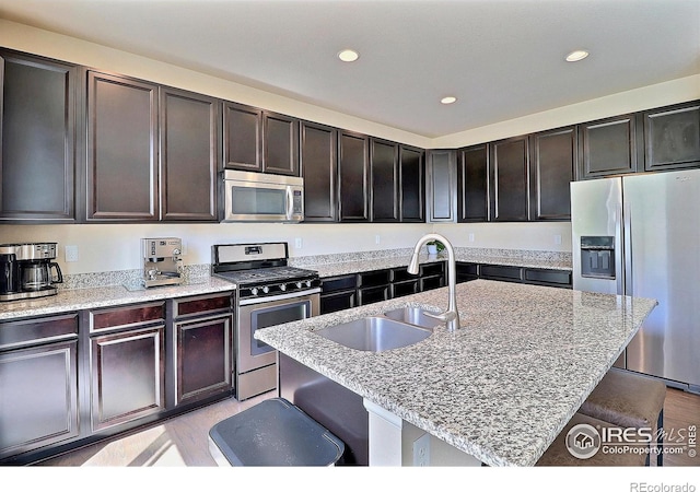 2927 Percheron Dr, Fort Collins, CO 80525 - kitchen featuring a sink, stainless steel appliances, recessed lighting, light wood-type flooring, and a kitchen bar