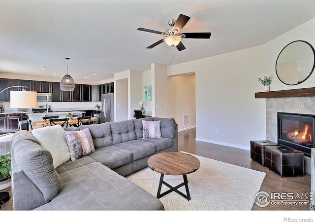 2927 Percheron Dr, Fort Collins, CO 80525 - living area with visible vents, wood finished floors, baseboards, a tile fireplace, and a ceiling fan