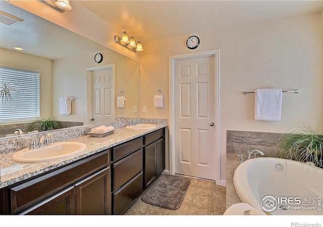 2927 Percheron Dr, Fort Collins, CO 80525 - full bathroom featuring double vanity, a freestanding bath, a sink, and visible vents