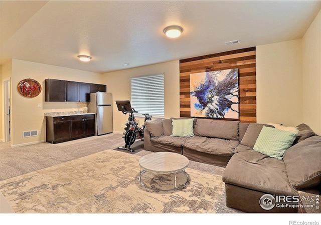 2927 Percheron Dr, Fort Collins, CO 80525 - living room featuring visible vents, wood walls, baseboards, and light carpet