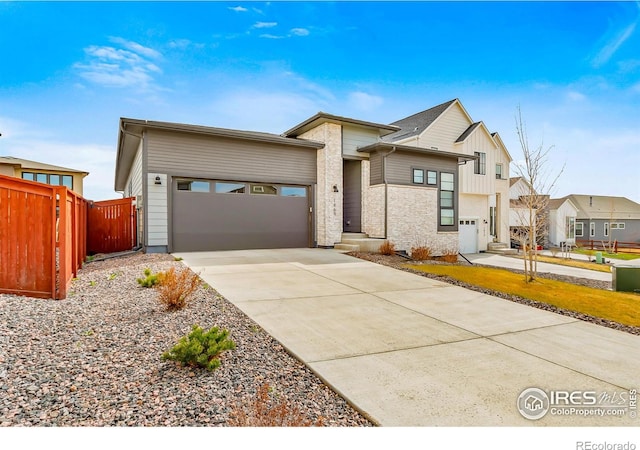 view of front of home featuring a garage, fence, and driveway