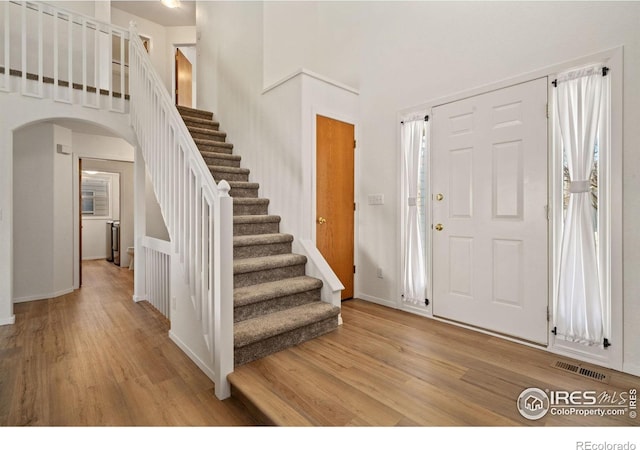 1532 Corydalis Ct, Fort Collins, CO 80526 - entryway featuring arched walkways, light wood-style floors, stairs, a towering ceiling, and baseboards