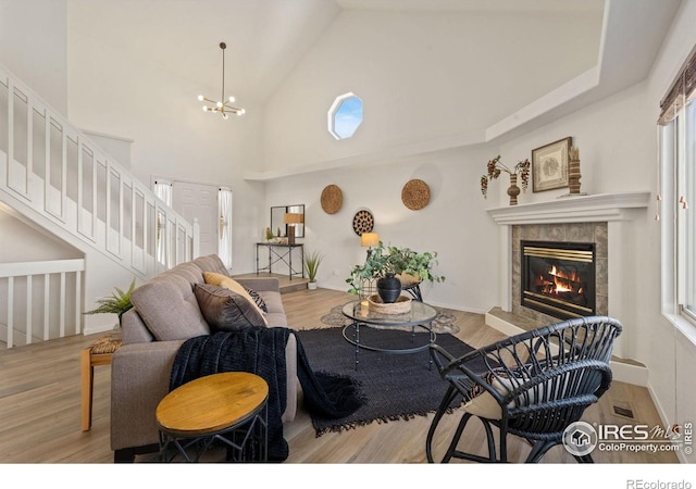 1532 Corydalis Ct, Fort Collins, CO 80526 - living room featuring a tile fireplace, stairway, wood finished floors, a chandelier, and high vaulted ceiling