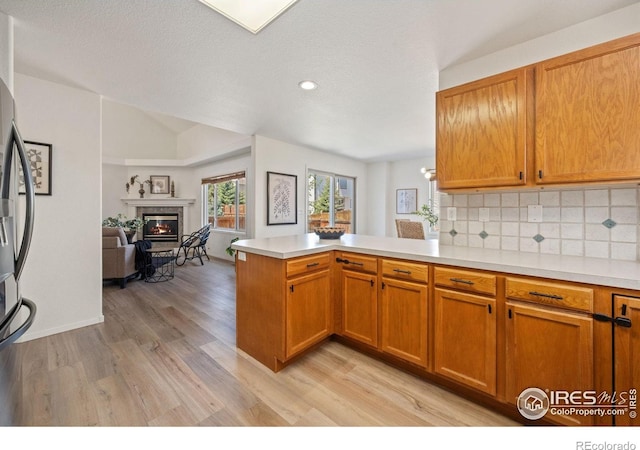 1532 Corydalis Ct, Fort Collins, CO 80526 - kitchen with a peninsula, light wood-style floors, light countertops, open floor plan, and tasteful backsplash