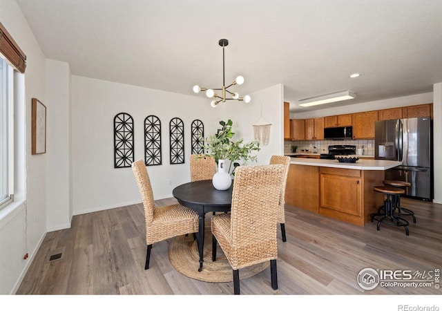 1532 Corydalis Ct, Fort Collins, CO 80526 - dining area with light wood finished floors, a chandelier, and baseboards