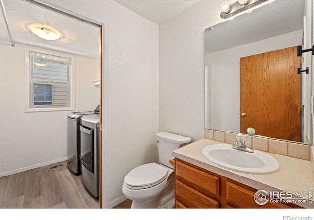 1532 Corydalis Ct, Fort Collins, CO 80526 - bathroom with independent washer and dryer, wood finished floors, vanity, toilet, and baseboards