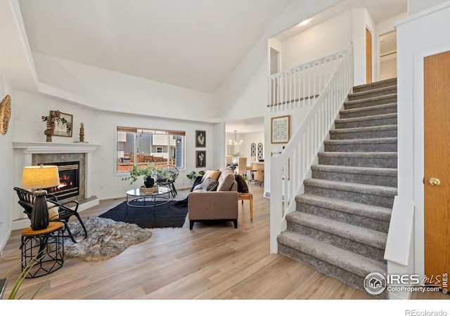 1532 Corydalis Ct, Fort Collins, CO 80526 - living area featuring stairs, wood finished floors, a glass covered fireplace, a chandelier, and a high ceiling