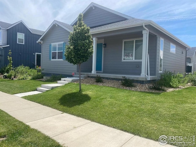 4672 Clear Creek Dr, Longmont, CO 80504 - view of front of home with covered porch, a shingled roof, and a front yard