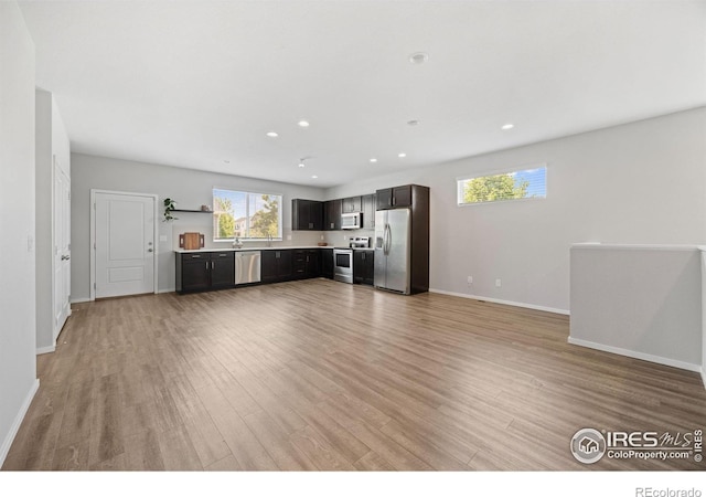 4672 Clear Creek Dr, Longmont, CO 80504 - unfurnished living room featuring light wood-style floors, plenty of natural light, baseboards, and recessed lighting